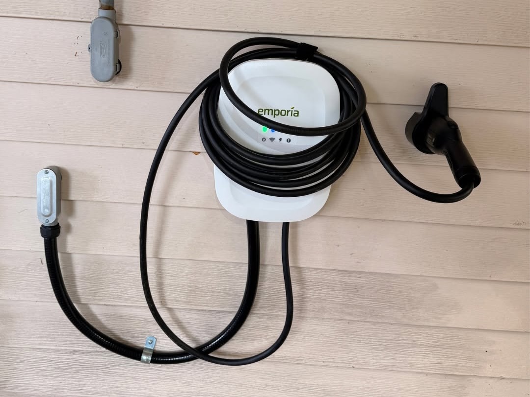 Emporia Level 2 EV charger installed outdoors on a Brush Prairie home with PVC conduit and exterior junction box